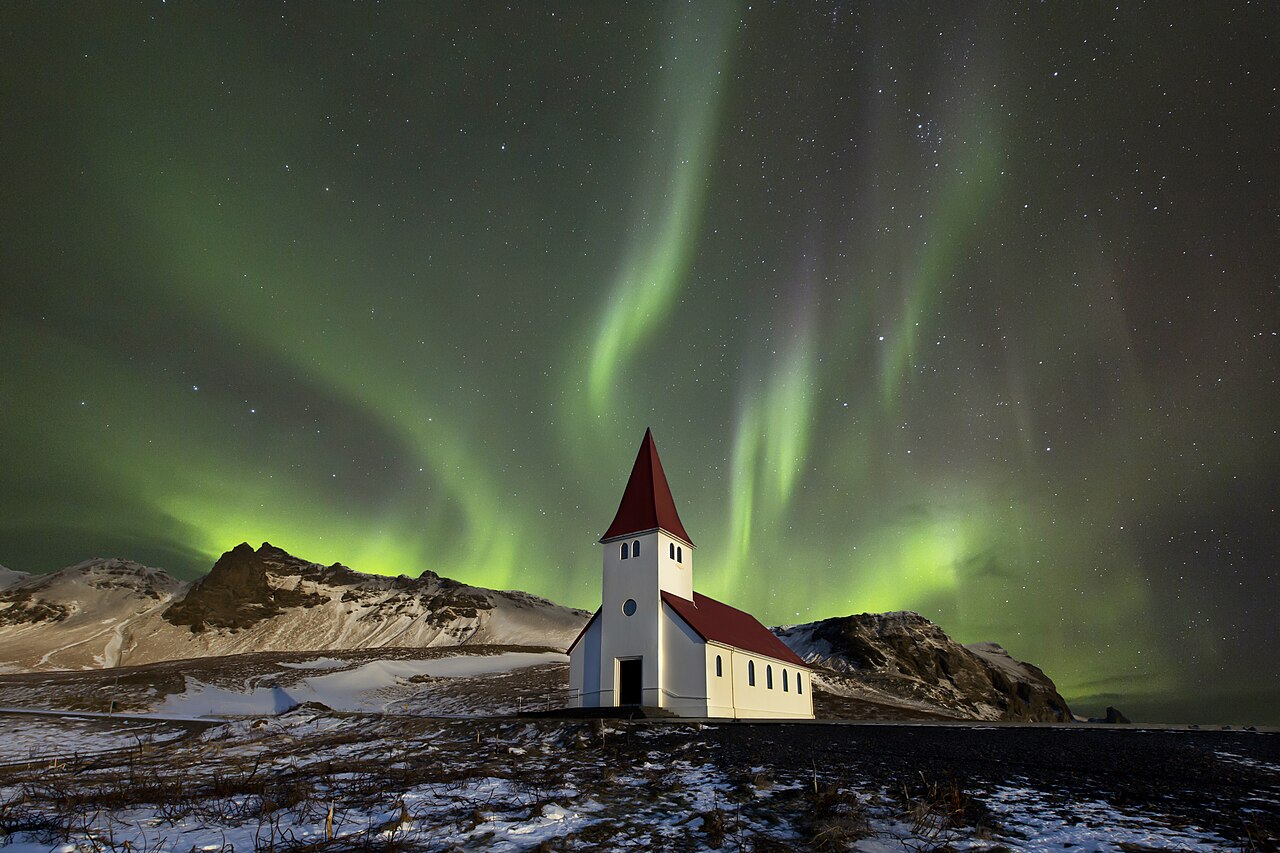 An aurora flowing over a small church in Iceland. Clear, dark, high-latitude winter nights are ideal viewing conditions.