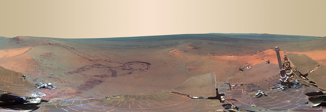 The surface of Mars and its yellowish sky, captured by the Opportunity rover. The iron-oxide dust suspended in the air dominates the scattering.