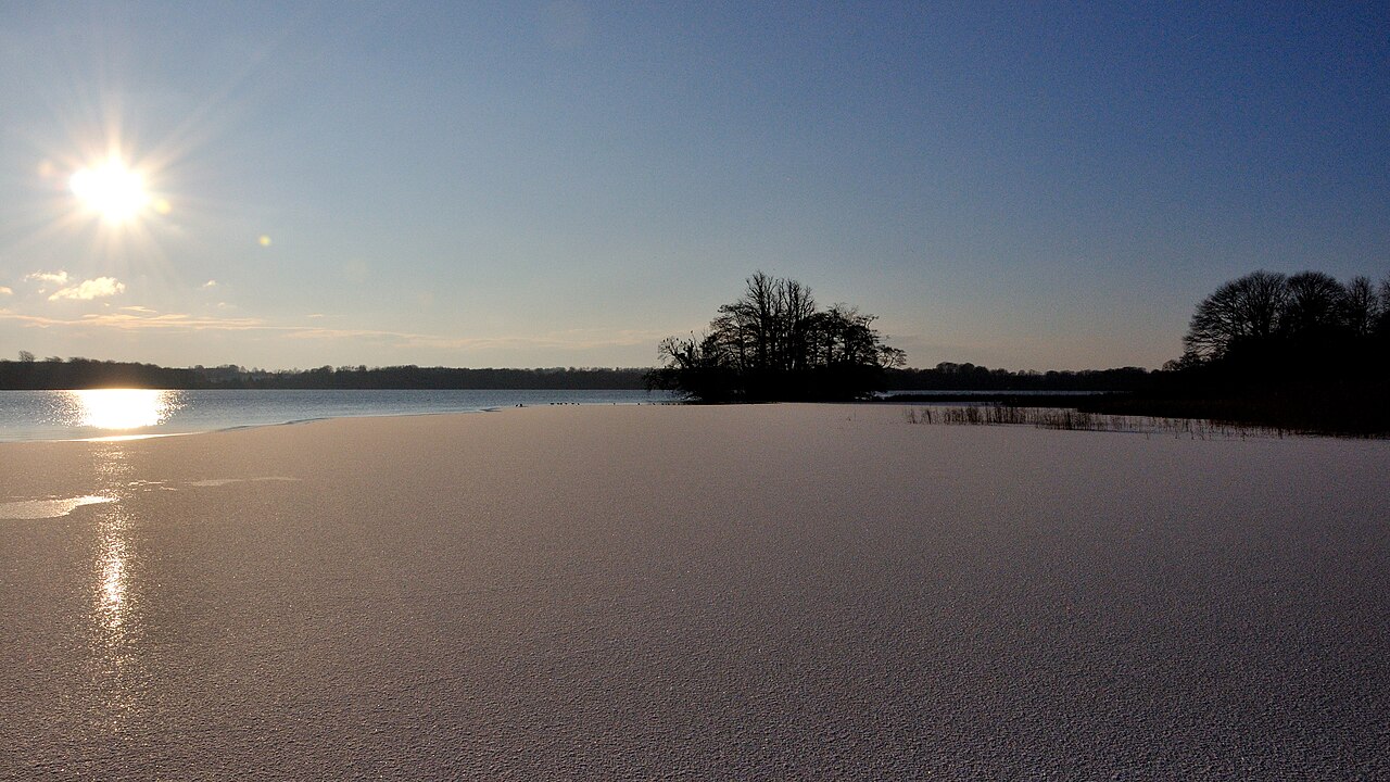 A layer of ice covering the surface of a winter lake. Less dense than water, the ice floats and covers the water beneath.