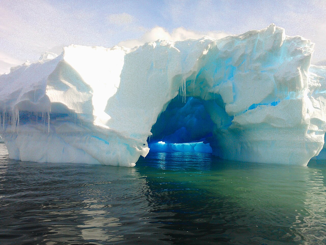 An iceberg floating in the sea. Less dense than seawater, only about 10% shows above the surface while most of it remains submerged.