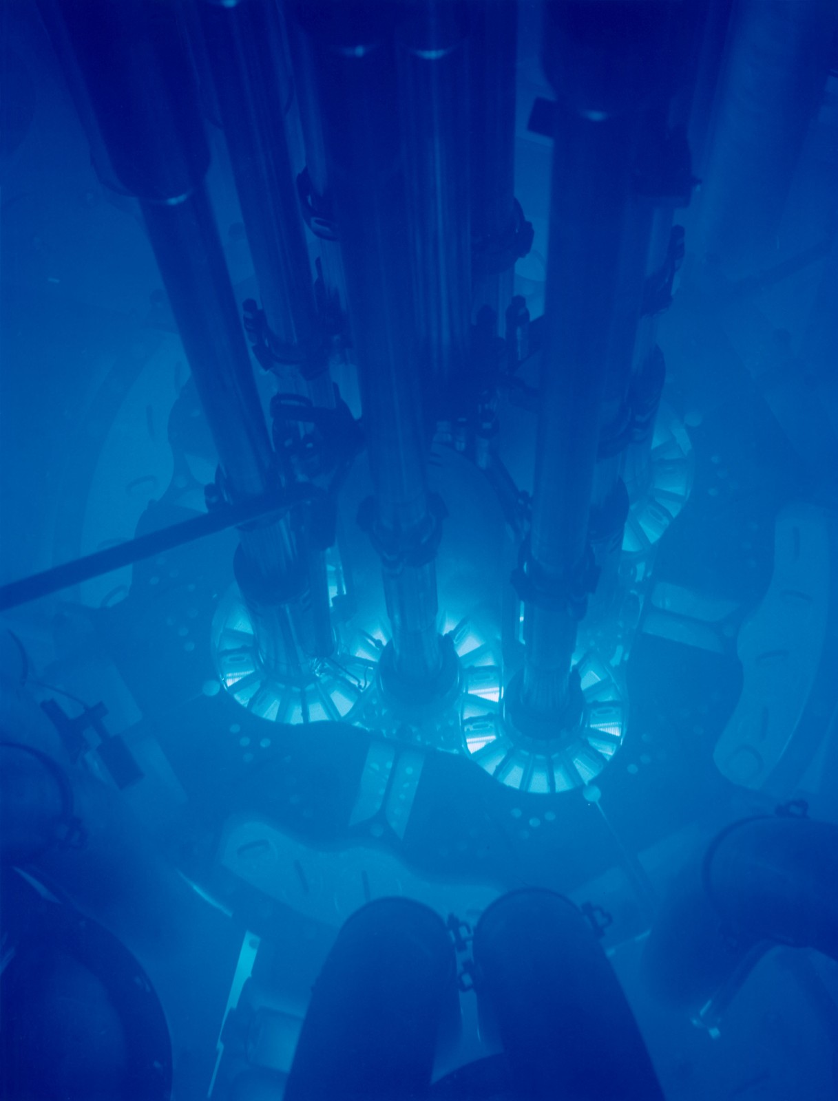 A reactor core submerged in water giving off a bright blue glow