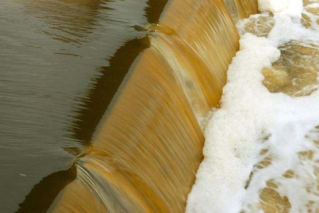 Muddy water rushing over a weir (Belfast)