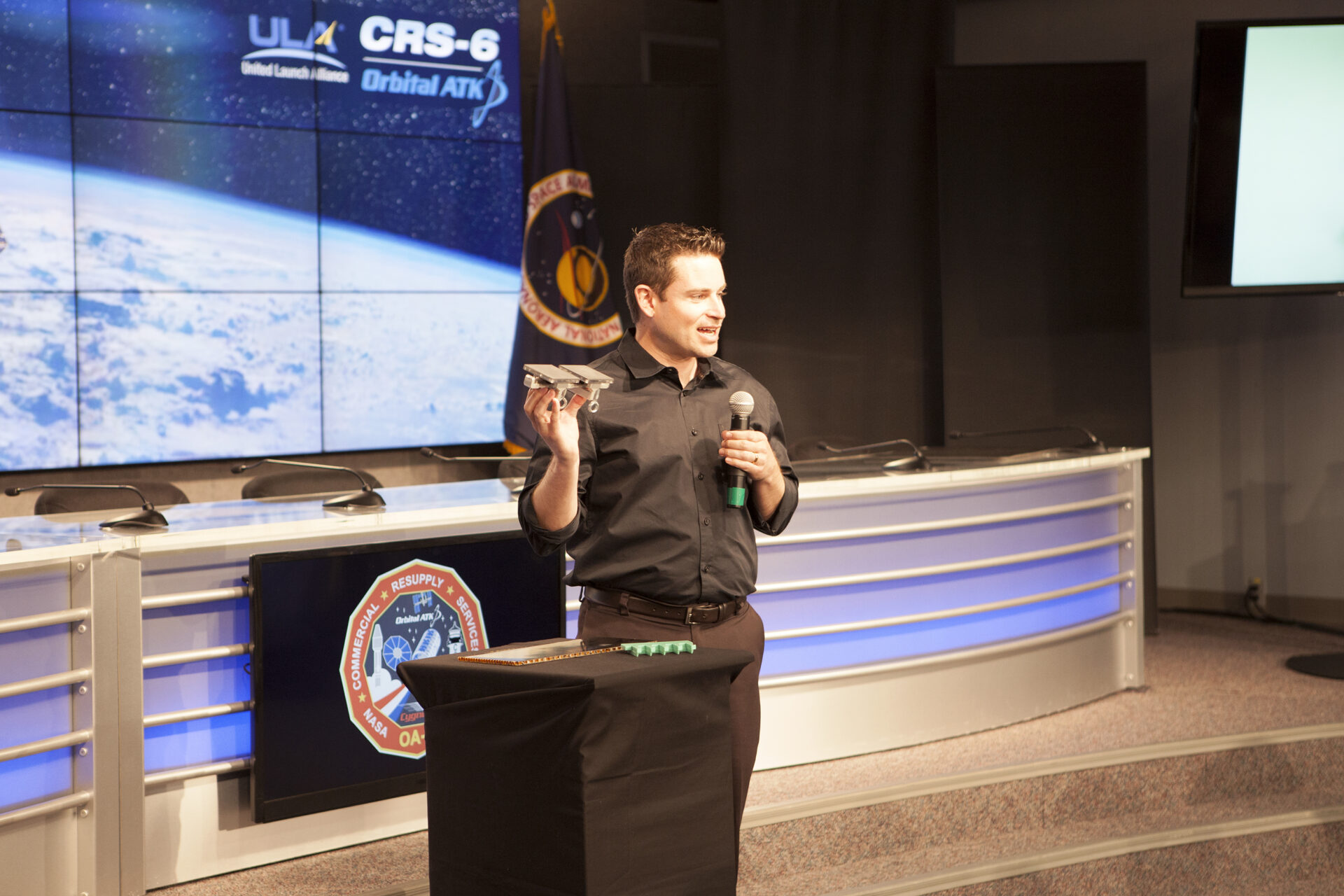 Aaron Parness, head of the NASA JPL gecko gripper project, speaking into a microphone at a briefing