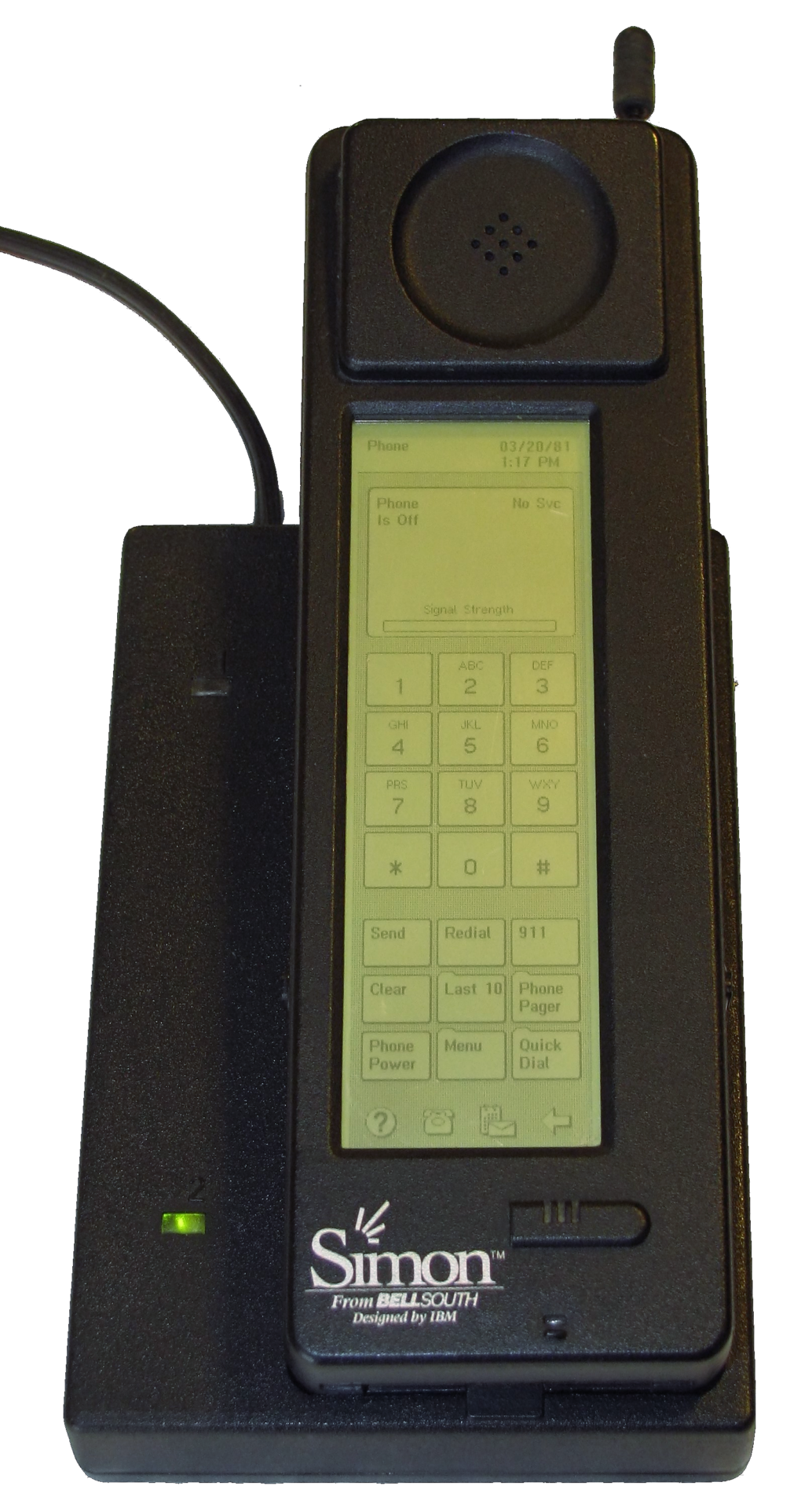 The IBM Simon (released 1994) seated in its charging cradle, shown at an angle that reveals both the screen and keypad. It was a commercial product that combined phone calls, a touchscreen, and fax and email apps in a single device.