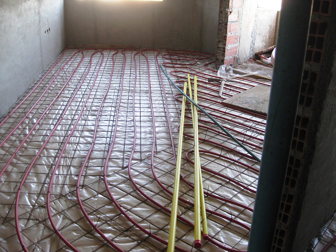 Hot-water ondol pipes laid in a grid over a moisture barrier and steel mesh on a new-build floor