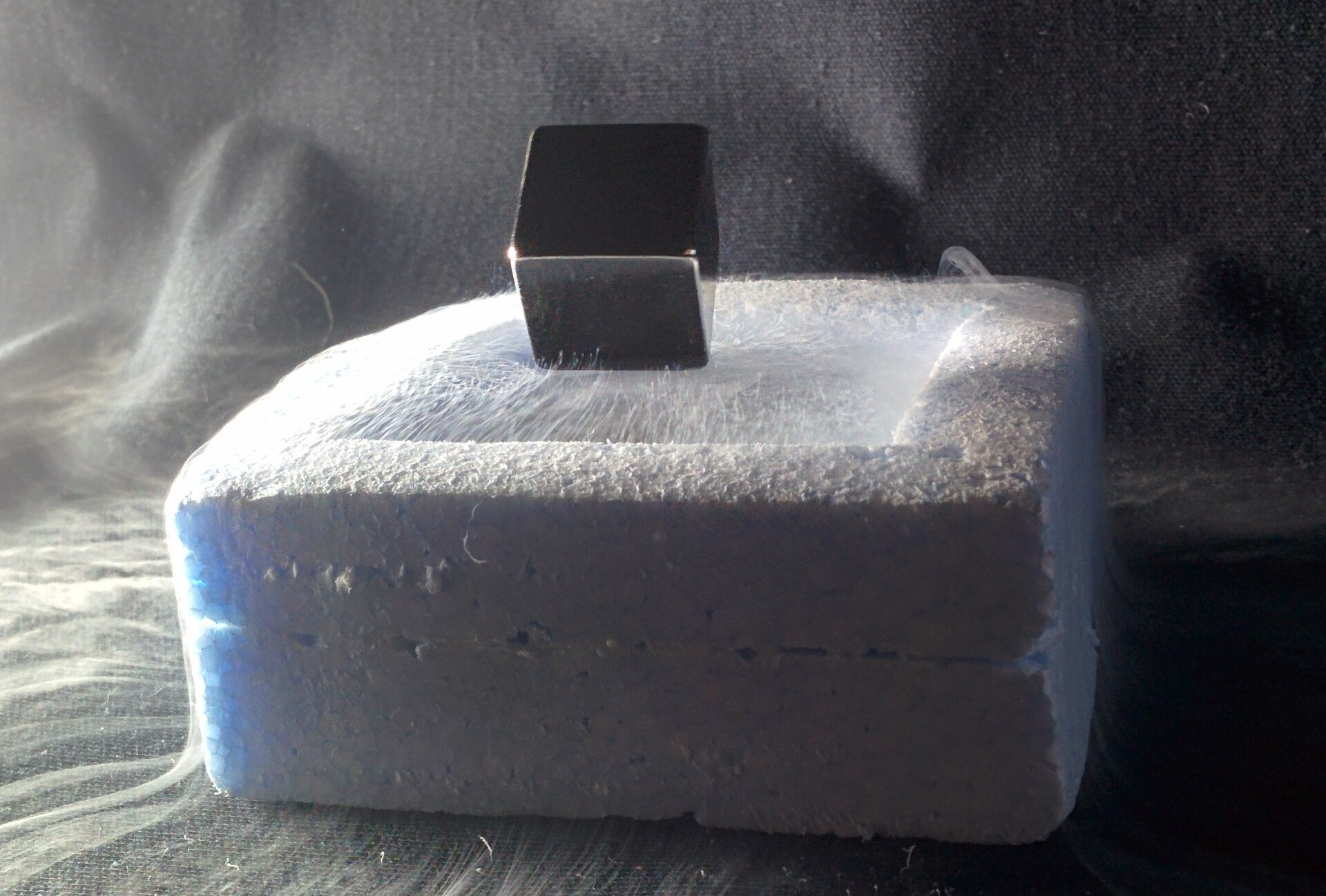 Photo of a magnet locked at a tilt above a superconductor