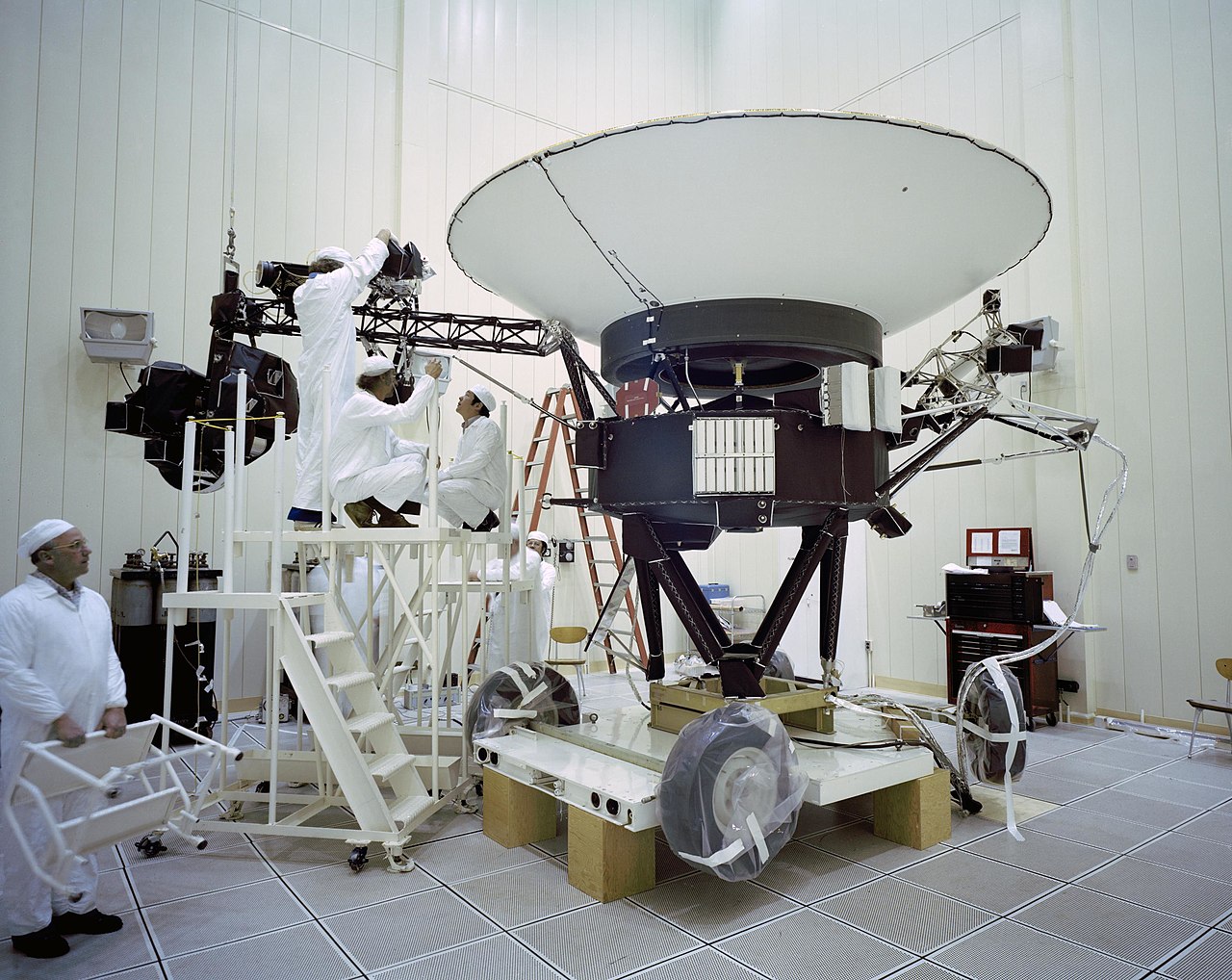 The gold-foil-wrapped Voyager spacecraft with its high-gain antenna, being assembled in a clean room