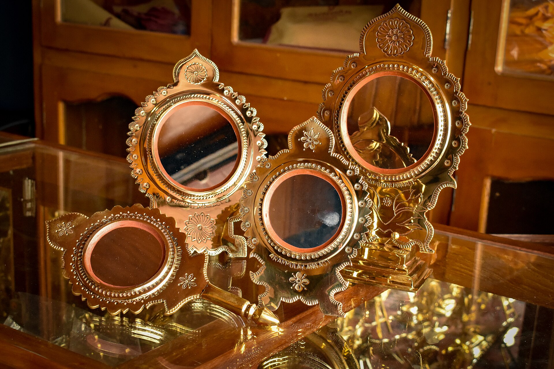 Several Aranmula metal mirrors with ornate frames on display