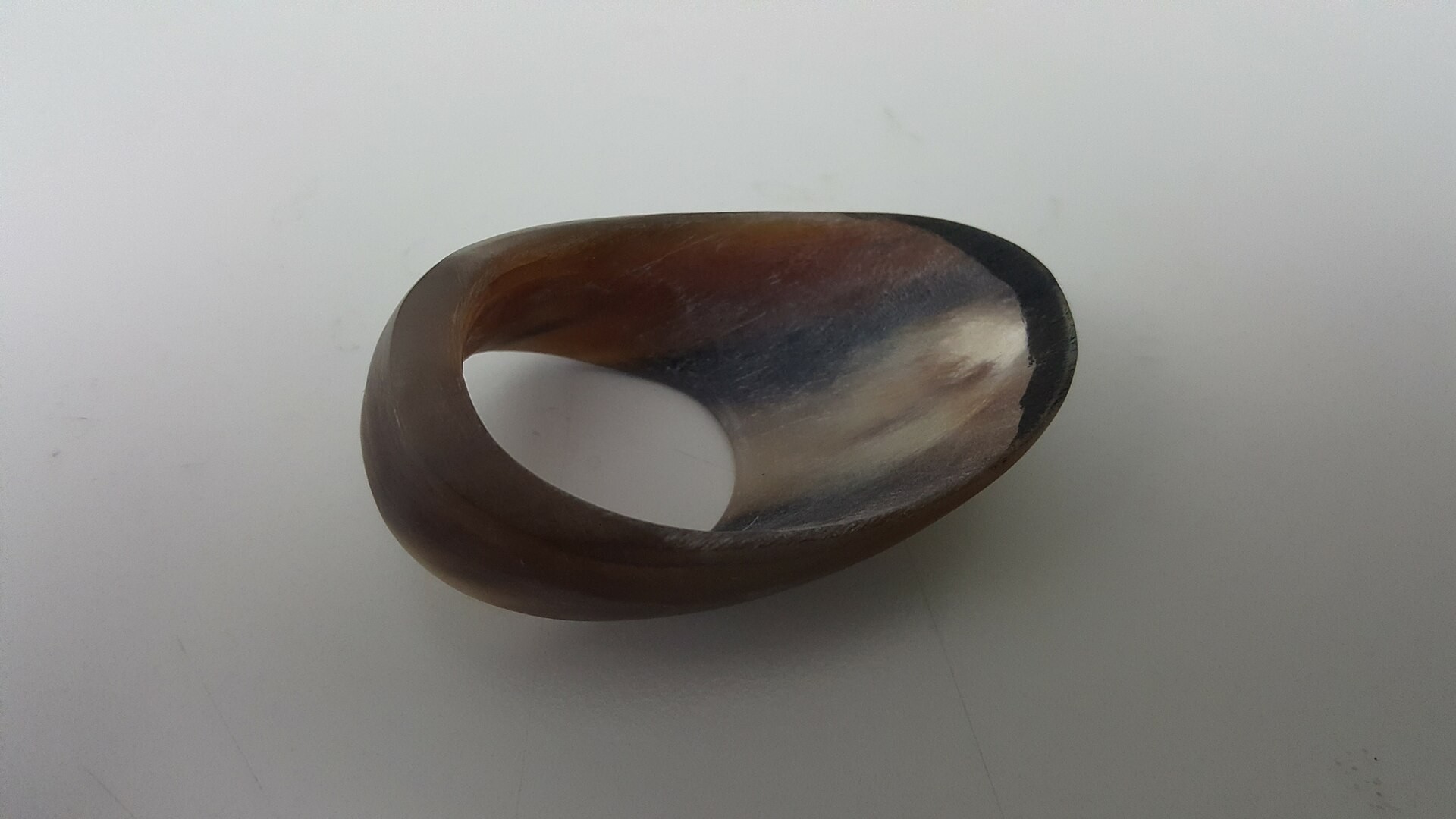 A ring-shaped thumb ring with brown streaks