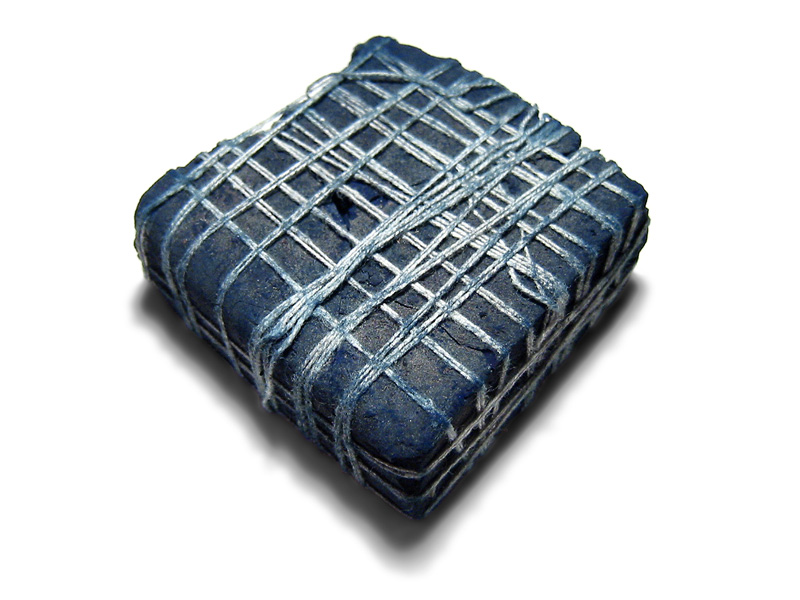 A lump of indigo dye from India, bound with string.