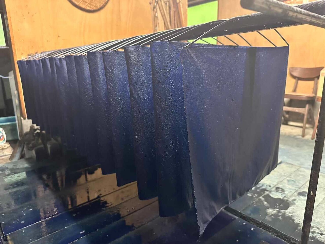 Blue fabric raised above the dye vat. This photograph shows fabric that is already blue.